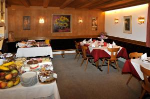 a restaurant with tables and chairs with food on them at Garni Halali in Ortisei