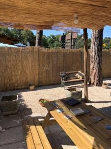una mesa de picnic de madera en un patio trasero con una valla en In villa, en Rocca di Papa