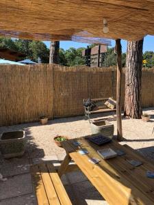 a wooden picnic table in a backyard with a fence at In villa in Rocca di Papa