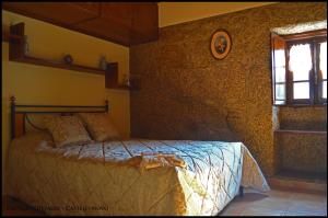 ein Schlafzimmer mit einem Bett in der Ecke eines Zimmers in der Unterkunft Castelo Cottages in Castelo Novo