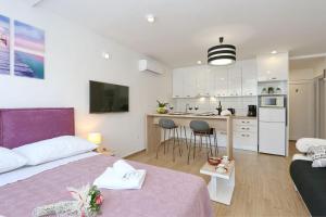 a bedroom with a bed and a kitchen with a table at Two new apartments by the town center in Zadar