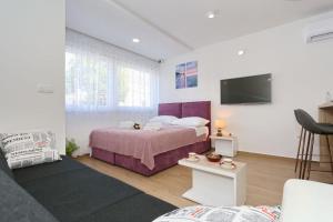 a bedroom with a bed and a tv on the wall at Two new apartments by the town center in Zadar