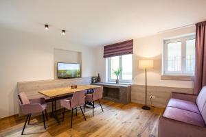 a living room with a table and chairs and a couch at Residence Rösch in Merano