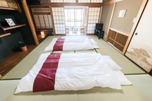 a row of beds in a room at Teradaya Osaka Ryokan 150m2 寺田屋大阪旅館 your own property sweet home in Osaka in Osaka