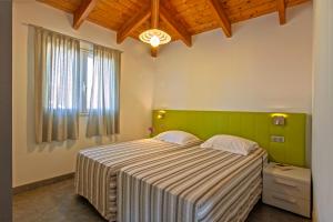 a bedroom with a large bed and a window at Résidence Arco Plage in Olmeto