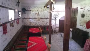 a room with two beds in a room with a wall at Узуновата къща in Melnik