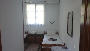 a small room with a bed and a window at Узуновата къща in Melnik