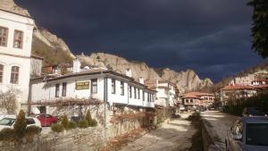 a street with houses and a mountain in the background at Узуновата къща in Melnik