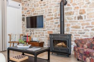 a living room with a stone wall with a stove at Rural House Kod Slapa in Bogatić
