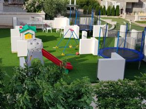 an outdoor playground with a slide and swings at Villa Crown Silvia in Dobra Voda