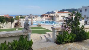 a view of a resort with a pool and a statue at Villa Crown Silvia in Dobra Voda