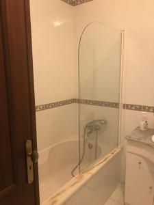 bagno con vasca e doccia in vetro di Hospedaria A Primorosa a Nazaré Altre 23 foto