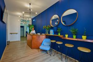 a woman standing at a counter in a blue room at Draggo House in Krakow