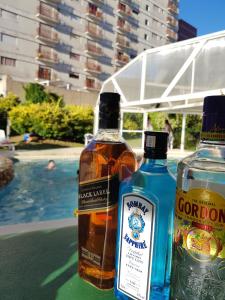 zwei Flaschen Alkohol auf einem Tisch in der Nähe eines Pools in der Unterkunft Hotel Chiavari in San Bernardo