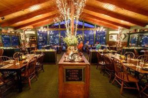 un restaurant avec des tables et des chaises et un lustre dans l'établissement Hungry Trout Resort, à Wilmington