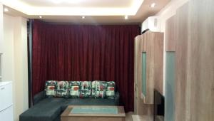 a room with a red curtain and a bed in a room at Luxury Apartment Neptune Center in Varna City