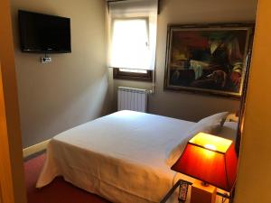 ナベスにあるLas Hortensiasのベッドルーム(ベッド1台、テレビ、ランプ付)