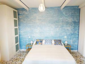 a bedroom with a bed with a blue wall at La Villa in Procchio