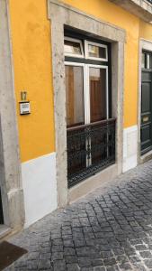 アブランテスにある4U Alojamento - Estúdioの黄色の建物(窓、バルコニー付)