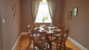 a dining room with a table and chairs and a window at Barcloy Honey House in Kirkcudbright