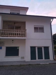 ヴィラ・ノーヴァ・デ・セルヴェイラにあるCasa do Artesanatoのバルコニー付きのホワイトハウスです。