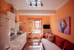 Una sala de estar con un sofá y una cocina. en Beach Holiday Home Fue, en Gran Tarajal