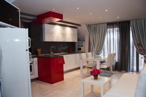 a kitchen with white cabinets and a white table with a dining room at Gran Via in Burgas City