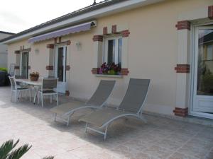 een patio met stoelen en een tafel voor een huis bij L'Escapade in Vertus