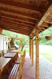 a wooden patio with wooden tables and chairs at Къща за гости Ради in Sapareva Banya