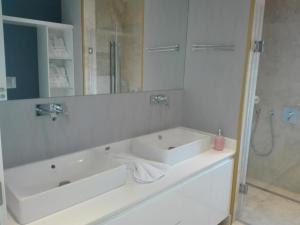 La salle de bains blanche est pourvue d'un lavabo et d'une douche. dans l'établissement Egesu Marina Guest House, à Gulluk