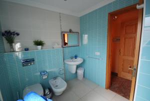Un baño azul con inodoro y lavabo. en Beach Holiday Home Fue, en Gran Tarajal