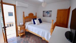 a bedroom with a wooden bed with blue pillows at Beach Holiday Home Fue in Gran Tarajal