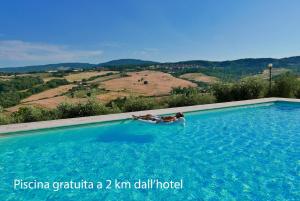 una persona sdraiata in una piscina con vista di Hotel Del Buono Wellness & Medical Spa a Chianciano Terme