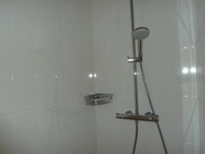 a shower with a strainer in a white bathroom at FEIJOA in Saint-Gély-du-Fesc
