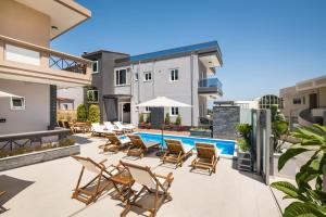 een patio met stoelen en een zwembad bij Sun Ray Luxury Apartments in Agia Marina Nea Kydonias