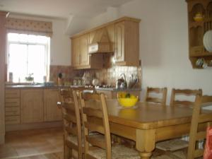 a kitchen with a wooden table with a yellow bowl on it at Beech House in Portballintrae