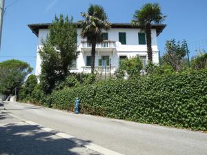 une maison blanche avec des palmiers et une bouche de feu bleue dans l'établissement Creska IV, à Rijeka