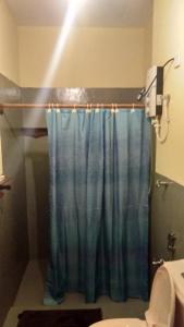 a bathroom with a shower with a blue shower curtain at Taragala Chalets in Kalametiya