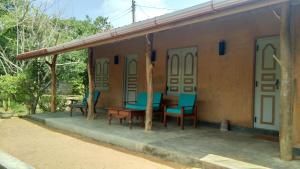 a house with a table and chairs on a patio at Taragala Chalets in Kalametiya
