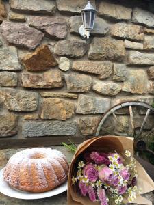 a cake and a bouquet of flowers next to a stone wall at Penzion Prezident in Soběraz