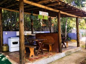 pérgola de madera con mesa y fogones en Pousada Alecrim, en Serra do Cipo