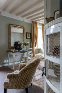 sala de estar con silla y espejo en Hôtel Tanquerey de La Rochaisière, en Coutances