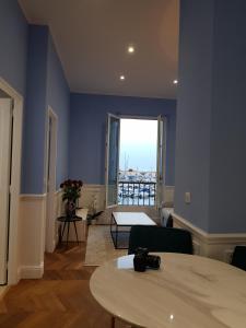 a blue room with a table and a large window at Tres Bel Appartement Vieux Port De Bastia in Bastia