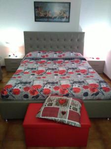 un letto con trapunta e ottomana rossa in una camera da letto di House Rose a Rose