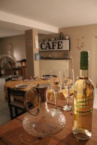 een fles wijn en twee wijnglazen op een tafel bij MUSTACH House in Saint-Maurice-sous-les-Côtes