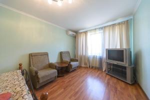 a living room with a television and two chairs at Prospekt Geroiv Stalingradu Apartments in Kyiv