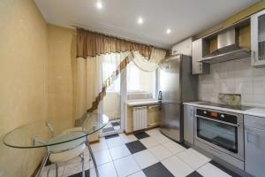 a kitchen with a glass table and a refrigerator at Prospekt Geroiv Stalingradu Apartments in Kyiv