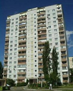 a large white apartment building with people walking in front of it at Prospekt Geroiv Stalingradu Apartments in Kyiv