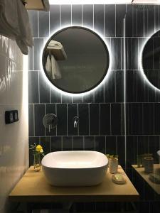 een badkamer met een witte wastafel en een spiegel bij Eleni's house in Finikounta