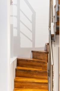 a stairwell with wooden stairs and a white wall at Oasis in Sarti